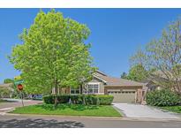 Charming single Gathering home with stone accents, a well-manicured lawn, and mature trees at 6673 S Benton St, Littleton, CO 80123