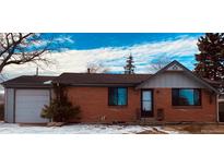 Brick ranch house with attached garage, and a landscaped yard at 153 S Pierce St, Lakewood, CO 80226