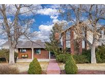 Charming brick two-story home with large windows and mature trees providing shade at 3308 S Birch St, Denver, CO 80222