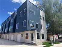 Modern townhome exterior with a blue and grey facade, large windows, and street view at 2140 S Ash St # 102, Denver, CO 80222