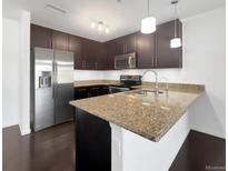 Modern kitchen features stainless steel appliances, granite countertops, and dark wood cabinets at 1062 Rockhurst Dr # 302, Highlands Ranch, CO 80129