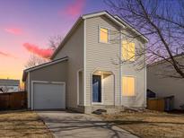 Charming two-story home features a classic facade, blue front door, and attached garage at 1242 Bluebird St, Brighton, CO 80601