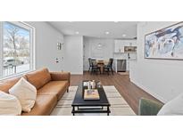 Open concept living room and kitchen area with hardwood floors at 2785 S Linley Ct, Denver, CO 80236