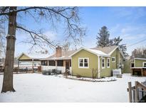 Charming single-story home with a brick chimney, adjacent carport, and a spacious snow-covered yard at 1205 Lee St, Lakewood, CO 80215