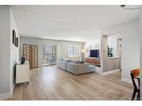 Bright living room boasts hardwood floors, access to balcony and neutral paint at 13952 E Marina Dr # 310, Aurora, CO 80014