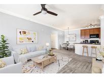 Bright living room boasts modern decor, open layout, and a smooth transition into the dining and kitchen area at 2662 S Cathay Way # 302, Aurora, CO 80013