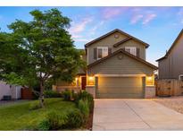 Charming two-story home featuring a well-manicured lawn, lush landscaping, and a spacious two-car garage at 777 Whispering Oak Dr, Castle Rock, CO 80104