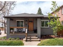 Charming gray brick home with a cozy front porch and manicured lawn at 489 S Gaylord St, Denver, CO 80209
