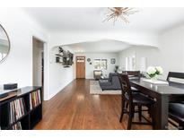 Open-concept living and dining area with hardwood floors and abundant natural light at 489 S Gaylord St, Denver, CO 80209