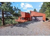 A distinctive modern two-story home with a two-car garage and rustic wood siding at 1278 Aspen Dr, Evergreen, CO 80439