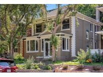 Charming two-story home with brick and siding, a front porch, and mature trees in a landscaped yard at 1419 N Adams St, Denver, CO 80206