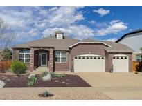 Charming brick home featuring an attached three-car garage, arched entryway, and landscaped front yard at 24621 E Berry Pl, Aurora, CO 80016