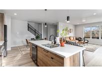 Open-concept kitchen flows seamlessly into the living and dining areas, with stainless steel appliances at 3580 W 62Nd Pl, Denver, CO 80221