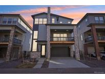 Modern three-story townhome with stone accents and a two-car garage at 15604 W Girard Ave, Morrison, CO 80465