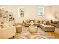 Bright and airy living room featuring built-in shelving, a comfortable sectional, and large windows at 1140 Columbine St # 106, Denver, CO 80206