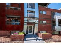 Modern brick condo building with metal accents and landscaped entry featuring flower planters at 75 N Emerson St # 104, Denver, CO 80218