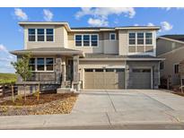 Two-story home with a three-car garage and modern stonework accents at 8601 Yellowcress St, Littleton, CO 80125