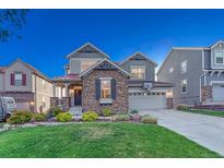 Charming two-story home with stone accents, well-manicured lawn and driveway basketball hoop at 12059 S Tallkid Ct, Parker, CO 80138