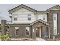 Charming two-story home featuring a brick facade, siding, covered entry, and a small balcony at 5107 S Fairplay St, Aurora, CO 80015