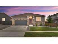 Charming single-Gathering home showcasing a well-maintained lawn, stone accents, and a two-car garage at 18071 Marsh Wren Ave, Parker, CO 80134