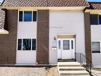 Exterior view of townhome featuring brick and vinyl siding, front door, and landscaping at 630 S Youngfield Ct, Lakewood, CO 80228
