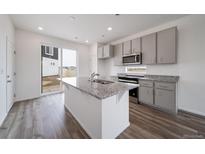 Modern kitchen with stainless steel appliances, granite countertops and a center island with sink at 22103 E 38Th Pl, Aurora, CO 80019