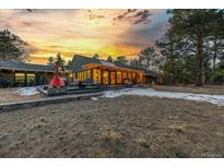 Stunning exterior view of home at sunset with landscaped yard and fire pit at 21577 Mountsfield Dr, Golden, CO 80401