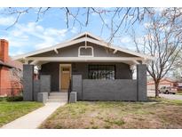 Charming single-story home with a gray brick facade and a yellow front door at 3600 N Race St, Denver, CO 80205