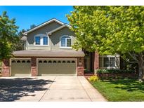 Inviting two-story home boasts a three-car garage, brick accents, lush lawn, and a mature shade tree at 10859 Irving Ct, Westminster, CO 80031