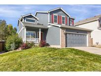 Charming two-story home with red shutters, a gray garage, and a well-manicured front yard at 9885 Thornbury Way, Highlands Ranch, CO 80129