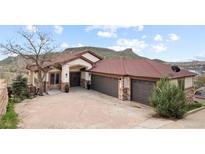 Beautiful single-story home with a two car garage, stone accents, and well maintained landscaping at 415 Butte Pkwy, Golden, CO 80403