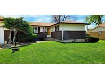 Charming single-story home with a well-manicured lawn, brick accents, and an inviting entrance at 9584 W Kentucky Ave, Lakewood, CO 80226
