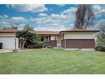 Ranch-style home with a well-maintained front yard, brick accents, and mature landscaping at 9584 W Kentucky Ave, Lakewood, CO 80226