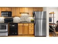 Modern kitchen features granite countertops, stainless steel appliances, and wood cabinets at 36 N Emerson St # 203, Denver, CO 80218