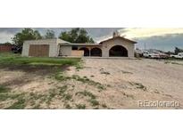 Ranch-style home with a unique arched carport and a spacious gravel driveway at 7115 Harold St # 2, Fort Lupton, CO 80621