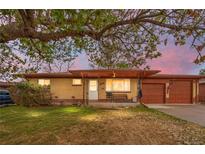 Charming brick ranch with a cozy front porch, mature trees, and attached two-car garage at 258 S 14Th Ave, Brighton, CO 80601
