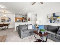 Inviting living room featuring comfortable seating and an open layout to the kitchen at 4451 S Ammons St # 4-203, Littleton, CO 80123
