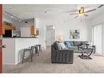 Open-concept living room with a breakfast bar, neutral paint, and comfortable seating at 4451 S Ammons St # 4-203, Littleton, CO 80123