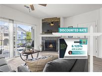 A cozy living room with a fireplace and a sliding door to a balcony in this condo at 4451 S Ammons St # 4-203, Littleton, CO 80123