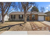 Charming single-story home featuring a combination of painted siding and brick exterior, complemented by a cozy, tree-lined front yard at 2638 S Lewiston St, Aurora, CO 80013
