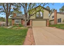Charming two-story home boasts a manicured lawn, brick accents, and attached two car garage at 7882 S Valentia Way, Centennial, CO 80112