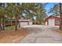 View of two-story home with attached two-car garage and additional detached garage with a basketball hoop at 35731 Elkridge Run, Elizabeth, CO 80107