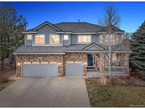 Charming two-story home with a brick and light blue exterior, well-manicured lawn, and an attached two-car garage at 6041 S Salida Ct, Aurora, CO 80016