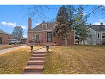 Charming brick home featuring a quaint front porch and well-maintained landscaping at 1545 Locust St, Denver, CO 80220