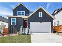 Charming two-story home features a red door, white garage, and modern architectural design at 16618 W 92Nd Pl, Arvada, CO 80007