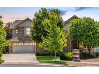 Charming two-story home featuring a stone facade, manicured landscaping, and an attached two-car garage at 27565 E Nova Pl, Aurora, CO 80016