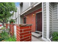 Townhouse front entrance featuring a brick facade, secure entry door, and well-maintained landscaping at 7474 E Arkansas Ave # 18-10, Denver, CO 80231