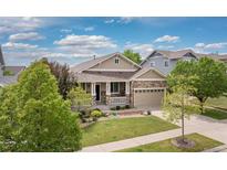 Charming single-Gathering home with stone accents, landscaped front yard and covered porch at 6520 S Newcastle Way, Aurora, CO 80016