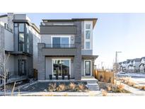 Modern three-story home with gray siding and a sleek design at 6202 N Galena St, Denver, CO 80238