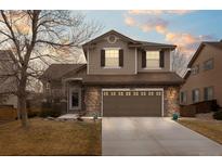 Charming two-story home with a two car garage, stone accents, and a well-manicured front yard at 9864 S Garland Ct, Littleton, CO 80127